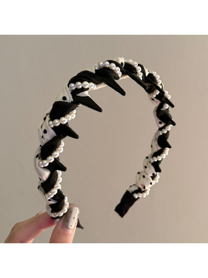 Close-up of black and white braided headband showing texture and pattern