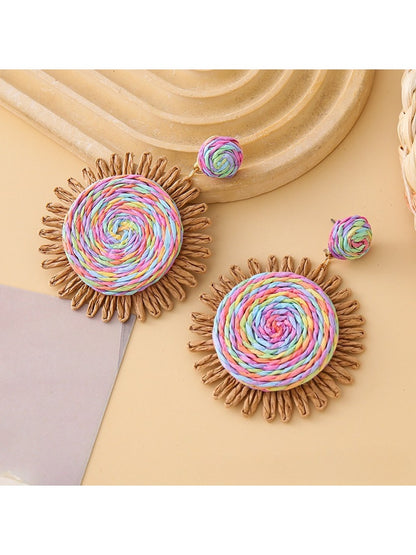 Side view of colorful raffia round earrings showing woven texture
