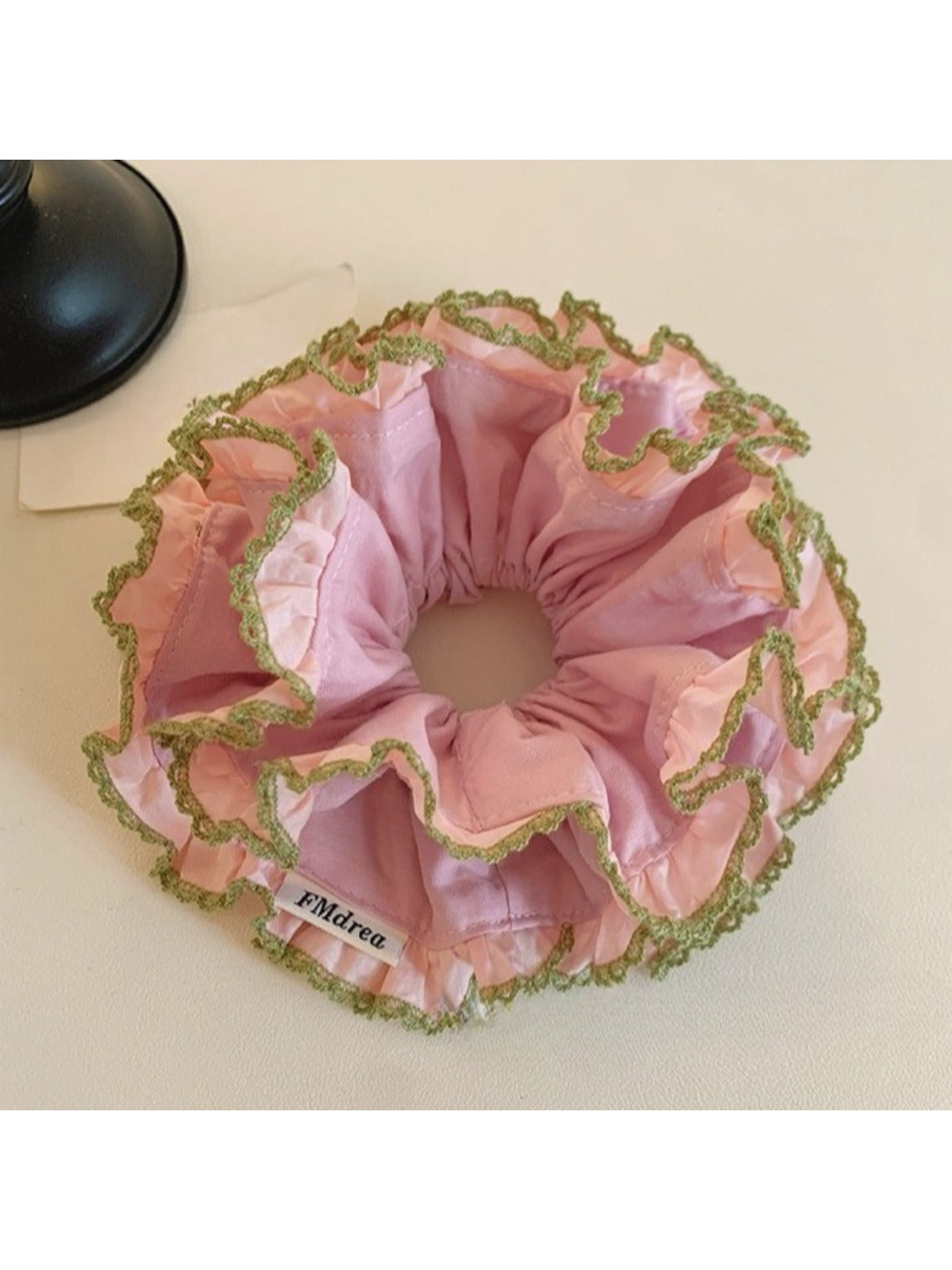 Pink lace trim double scrunchie displayed on a wooden surface