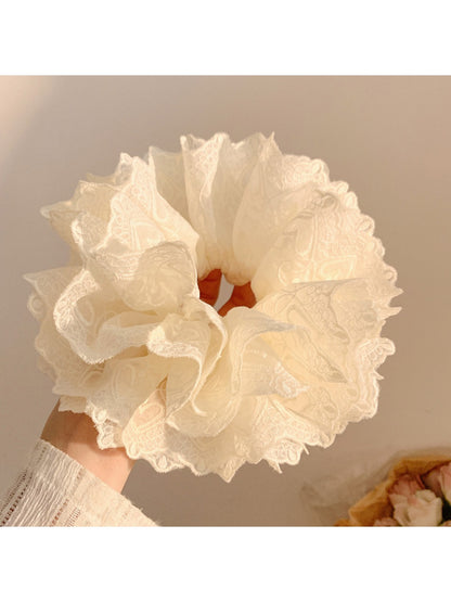 White ruffled scrunchie displayed flat highlighting its volume and layers