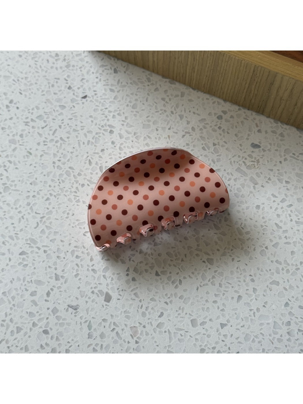 Beau polka dot claw clip holding a section of blonde hair