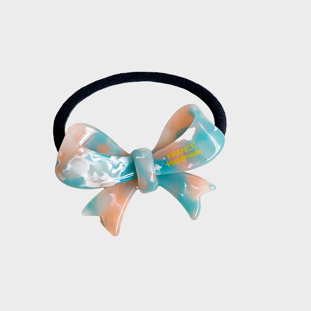 IridOrgBlu Gifty - Iridescent Bow Hair Tie on neutral background